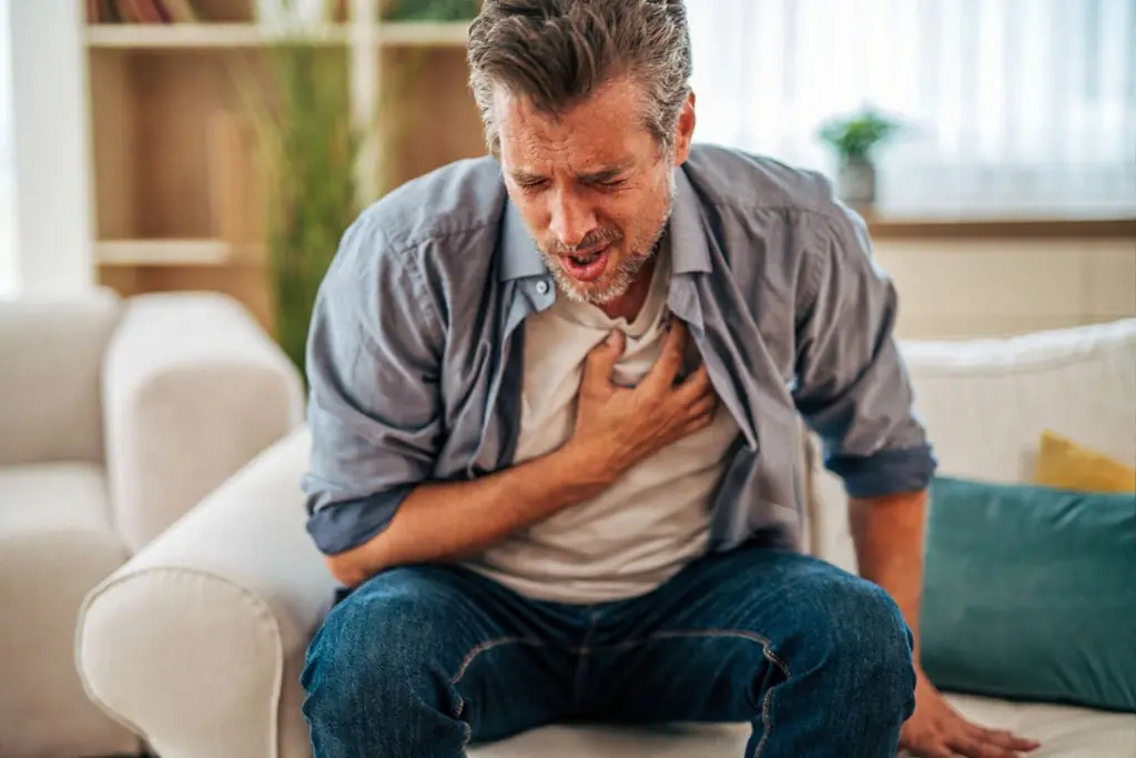 Young Man holding heart, heart health risk